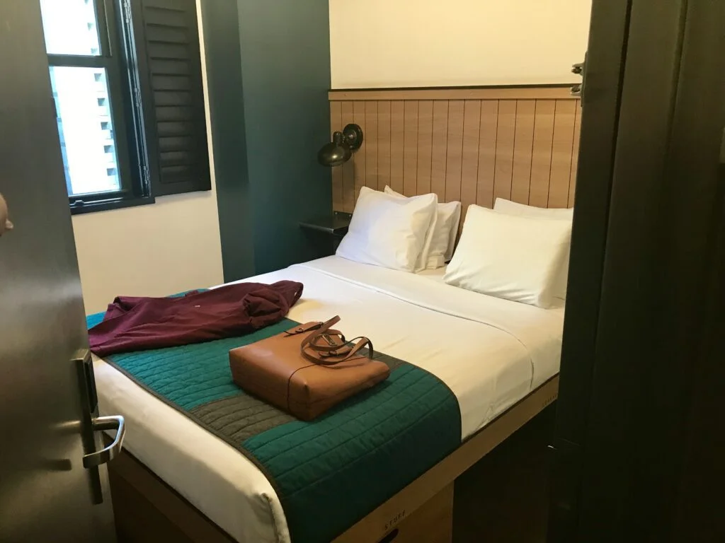 Pod 39 Hotel Room: A compact, modern hotel room at Pod 39 with a neatly made bed, minimal furnishings, and efficient use of space, evoking the feel of a ship stateroom.
