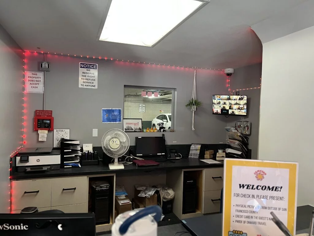 Front desk of Samesun Hostel with a window overlooking the parking garage.