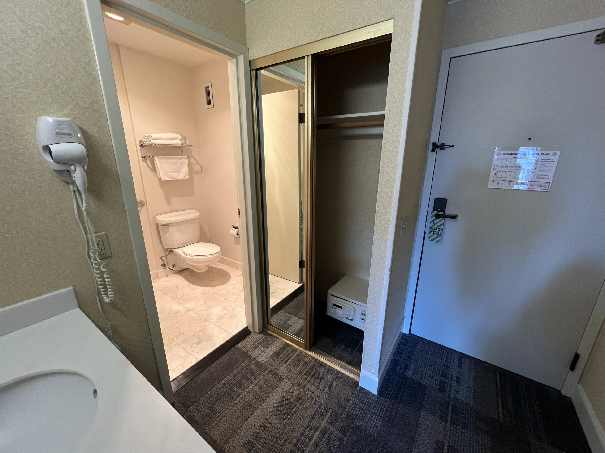 Closet with hangers and a safe.