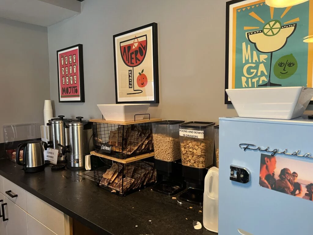 Breakfast bar offering coffee, tea, yogurts, fruit, and cereal.