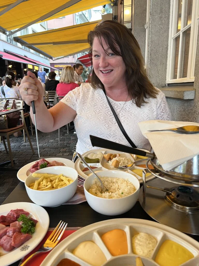 Swiss Chuchi Restaurant Fondue: A pot of traditional Swiss cheese fondue served at Swiss Chuchi Restaurant in Zurich, accompanied by bread cubes and pickles.