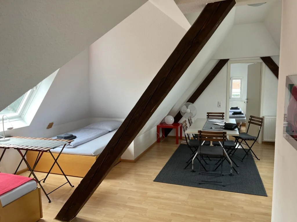 Black Forest Bike Hostel Main Room: The main room of the Black Forest Bike Hostel, featuring a cozy kitchen area and two double beds, offering a comfortable stay.