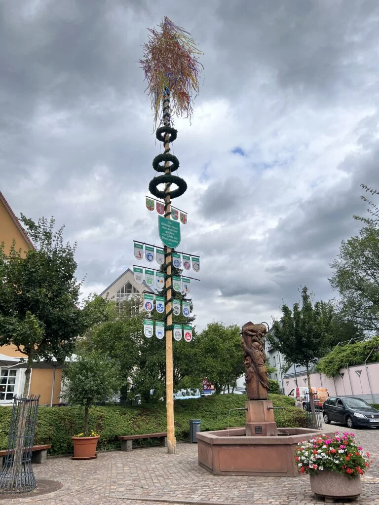 Kirchzarten Maypole: Close-up of the maypole in Kirchzarten, decorated with colorful ribbons and emblems, symbolizing local traditions.