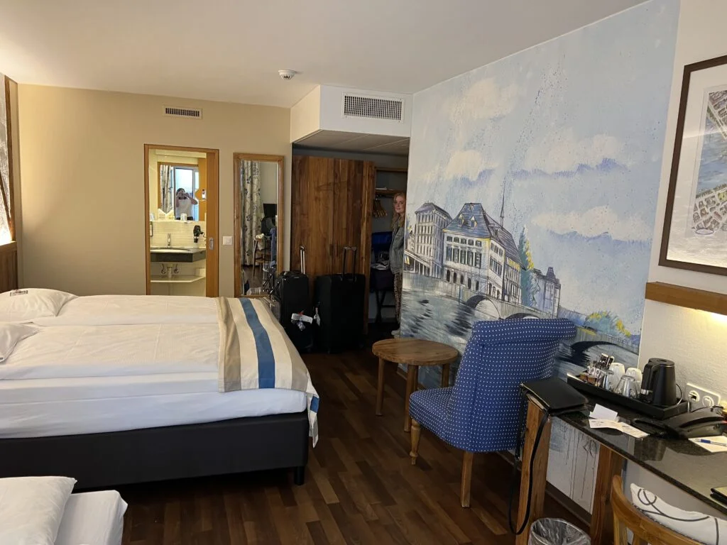 Hotel Adler Zurich Room: A well-appointed room at Hotel Adler Zurich, featuring a double bed, modern amenities, and a balcony overlooking a charming square.