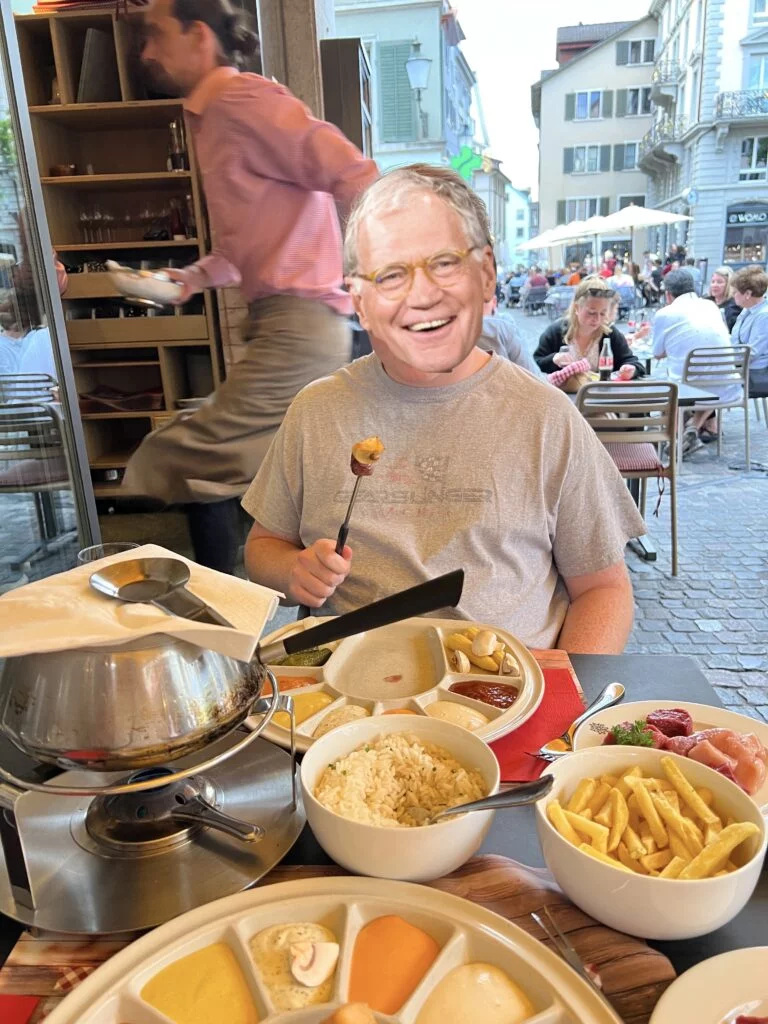 Swiss Chuchi Restaurant Fondue: A pot of traditional Swiss cheese fondue served at Swiss Chuchi Restaurant in Zurich, accompanied by bread cubes and pickles.