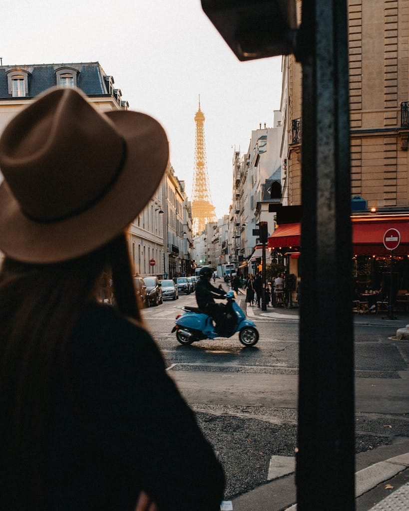 Planning a Trip to Paris 4 View of Eiffel Tower from a Paris street with a scooter and pedestrian.