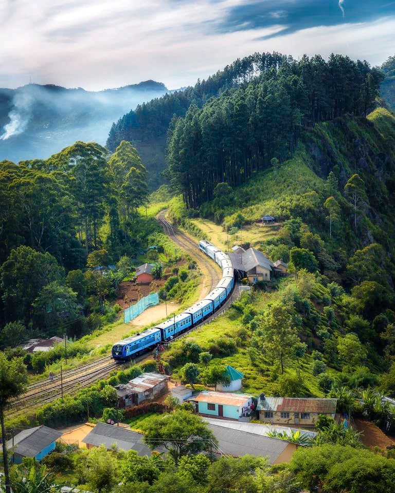 Planning Your California Zephyr Experience: Best Stops and Cool Hotels 38 Aerial view of a picturesque train winding through lush green hills and rural houses.