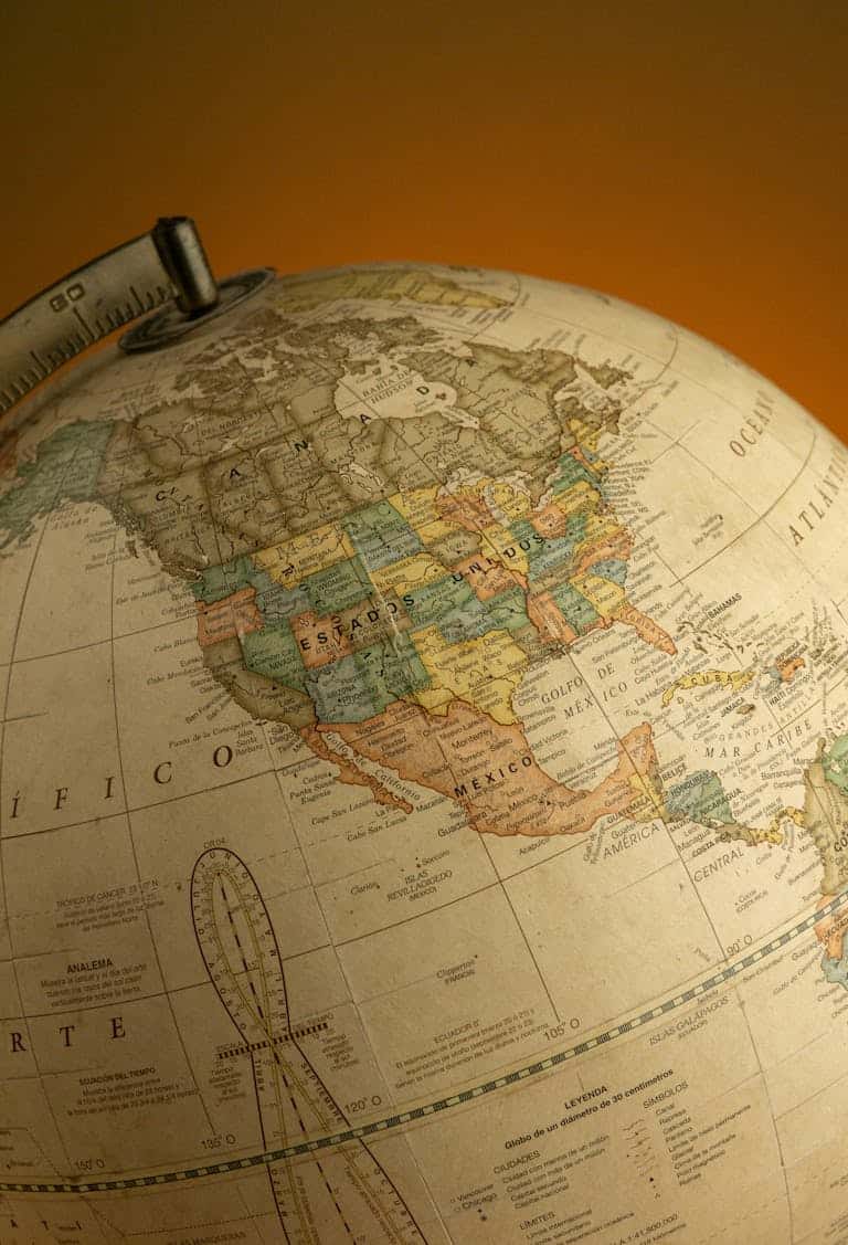 A close-up of a vintage globe highlighting North America, captured with warm lighting.