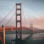 Golden Gate Bridge shrouded in fog during sunset, San Francisco.