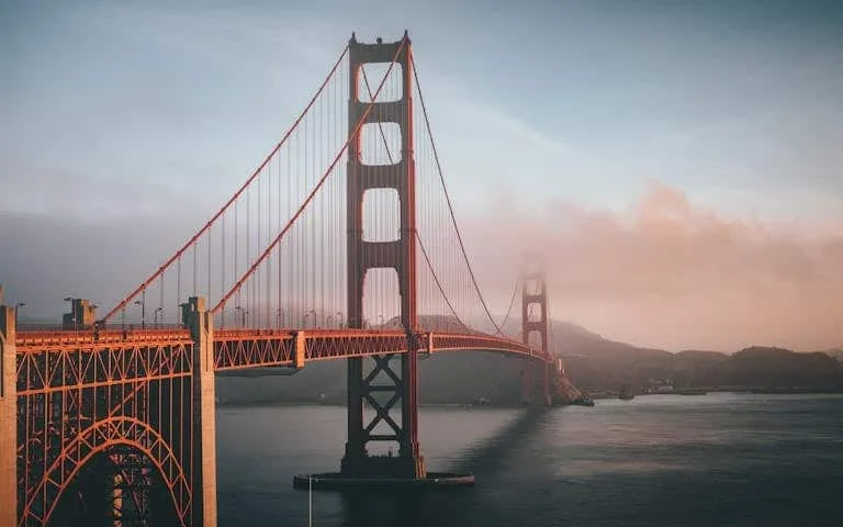 Golden Gate Bridge shrouded in fog during sunset, San Francisco.