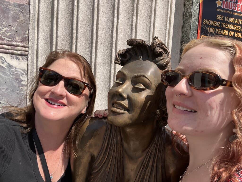 2 women posing with the Marilyn Monroe Bronze statue outside Hollywood Museum