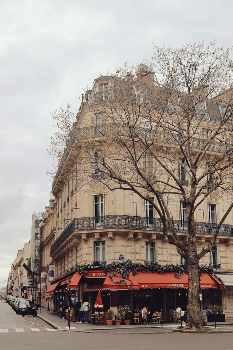 Elegant street view in Paris, capturing a classic corner cafe and architecture.