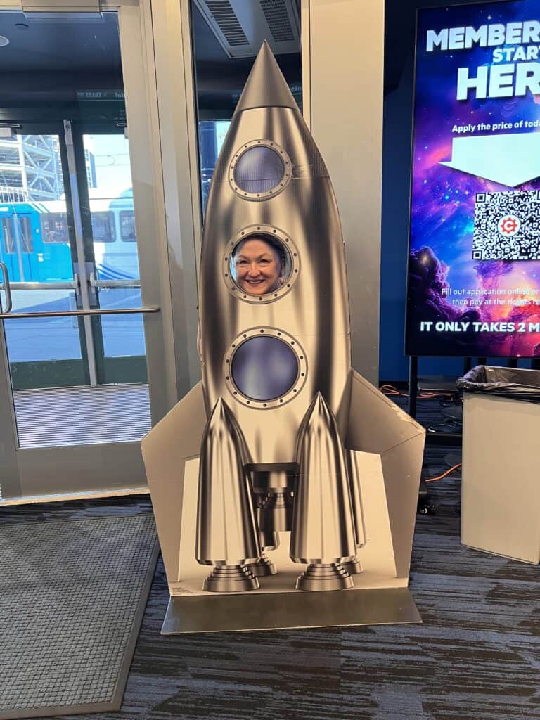 Sue in rocket cutout at Clark Planetarium
