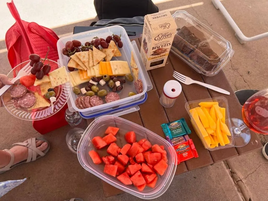Cabana table covered with sushi rolls, fruit, brownies, and drinks
