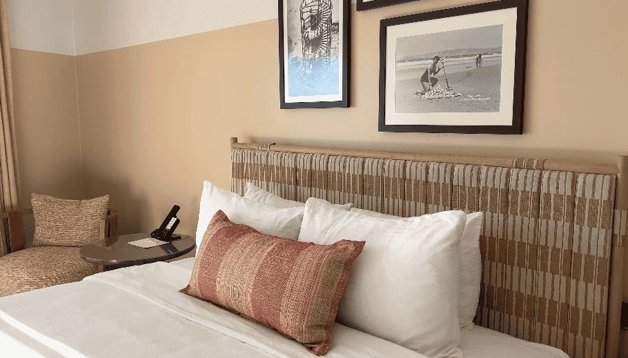 Pacific Point Resort Pismo Beach Review: What It’s Really Like to Stay (With My Dog) 6 Interior of a renovated guest room at Pacific Point Resort, with a large Pismo Beach photograph on the wall behind the television and a long storage bench running beneath it